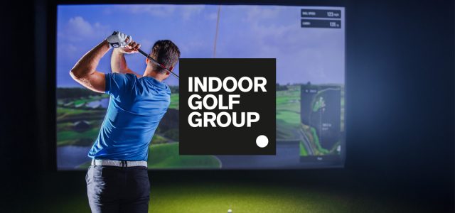 Indoor golf simulator with a man swinging his club. He is wearing a blue t-shirt. A logo for the Indoor Golf Group is in the center above the image.